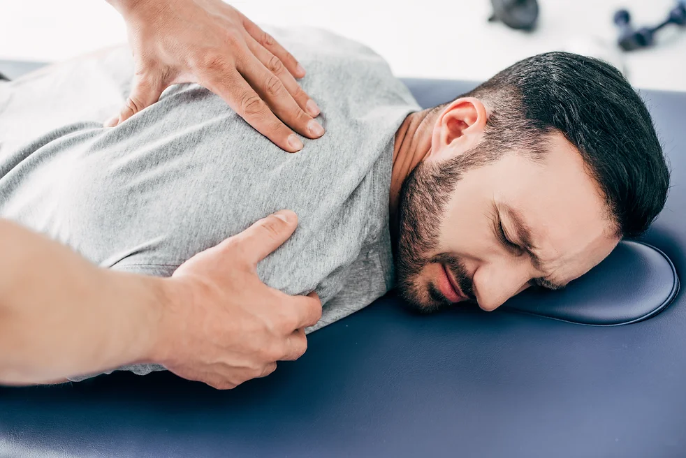 chiropractor-massaging-back-of-man-on-massage-tabl-2022-11-01-23-10-29-utc