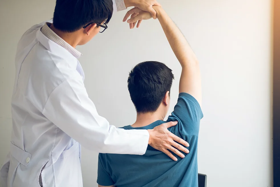 chiropractor-stretching-a-young-man-arm-in-medical-2022-10-06-05-53-33-utc